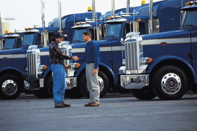 Truck drivers shaking hands in parking lot
